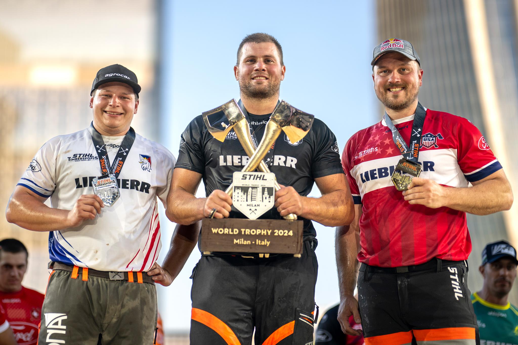 Matyas Klima of Czech Republic, Jack Jordan of New Zealand and Matthew Cogar of the United States celebrate during the STIHL TIMBERSPORTS® World Trophy 2024 in Milano, Italy on May 25, 2024.